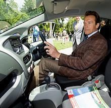 Der Gouverneur des amerikanischen Bundesstaates Kalifornien, Arnold Schwarzenegger, am Lenkrad des rechtsgesteuerten i-MiEV